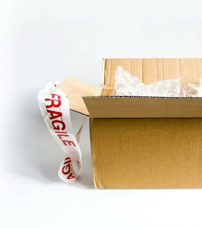 Otwarty karton klapowy z folią bąbelkową i taśmą „FRAGILE" — wybór opakowania do wysyłki w e-commerce